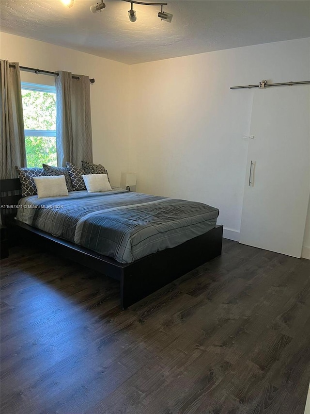 bedroom with dark wood-type flooring