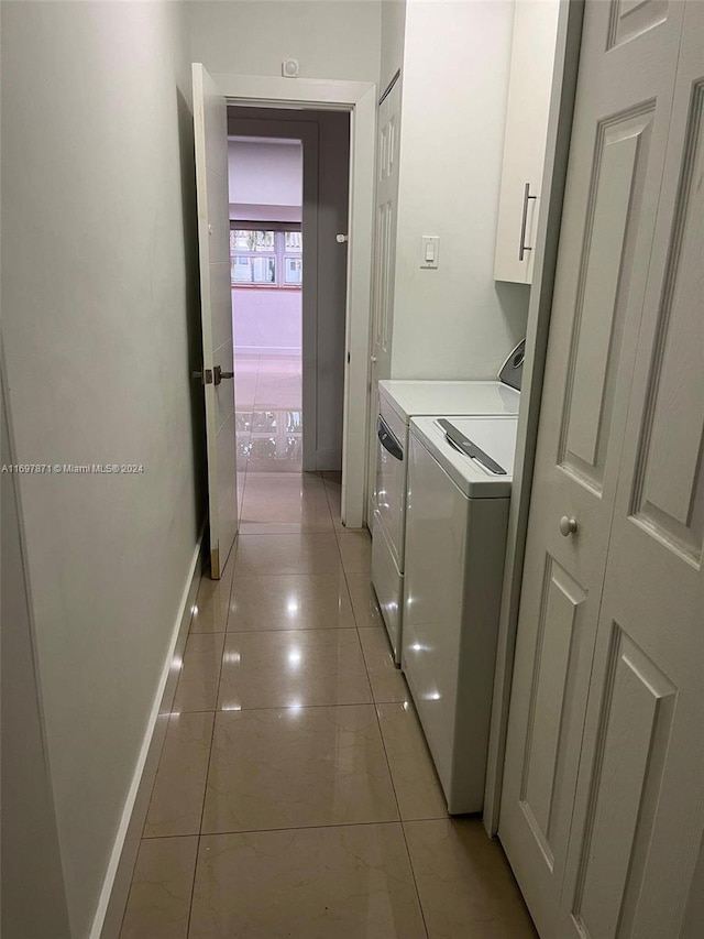 washroom featuring washer and dryer, light tile patterned floors, and cabinets