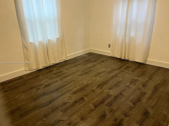 unfurnished room with dark hardwood / wood-style flooring