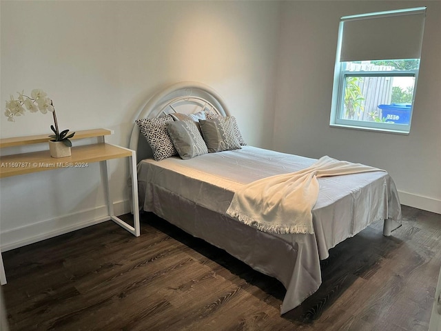 bedroom with dark hardwood / wood-style floors