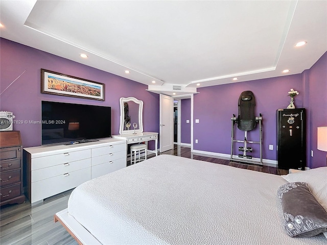 bedroom featuring hardwood / wood-style floors and a tray ceiling