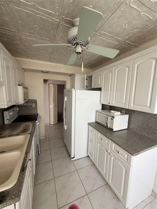 kitchen featuring white appliances, ceiling fan, sink, light tile patterned floors, and white cabinets