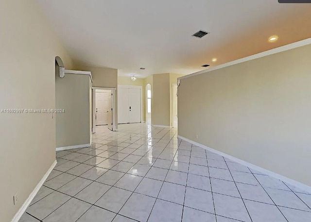 spare room with light tile patterned floors and ornamental molding