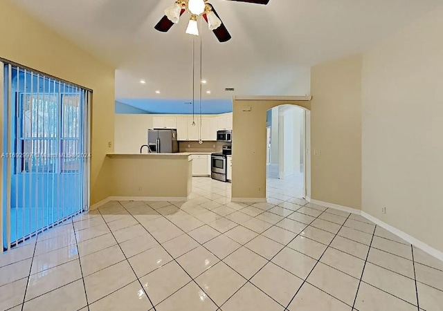 kitchen with kitchen peninsula, ceiling fan, light tile patterned floors, white cabinetry, and stainless steel appliances