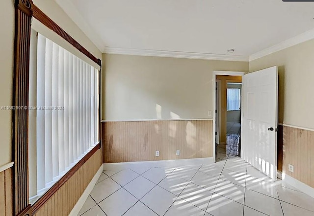 tiled spare room with crown molding