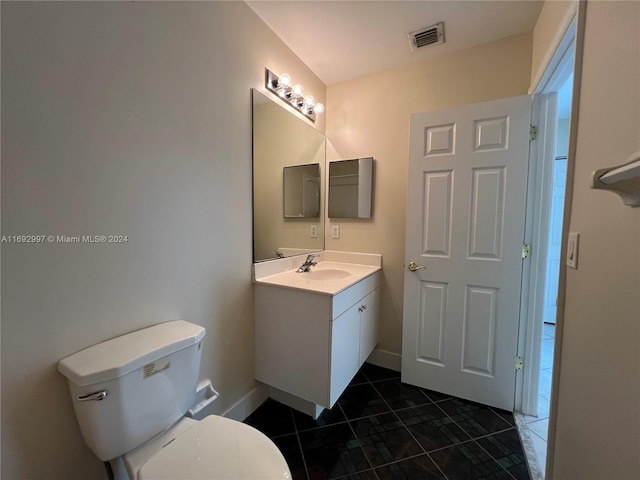 bathroom featuring tile patterned floors, vanity, and toilet