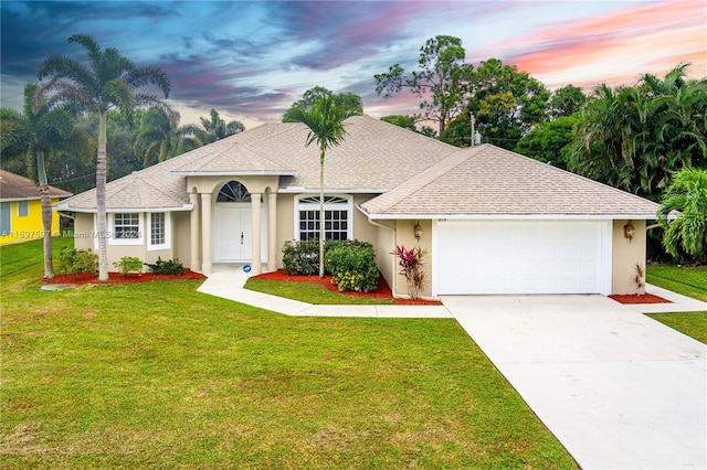 ranch-style home featuring a lawn and a garage