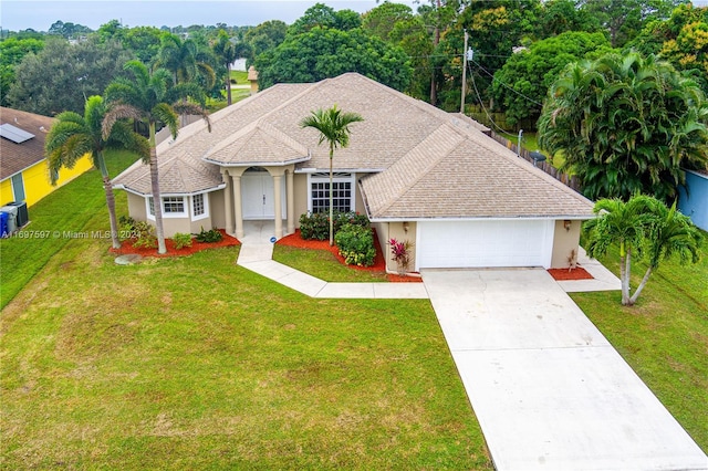 ranch-style house with central air condition unit, a front yard, and a garage