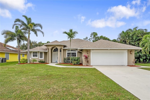 ranch-style home featuring cooling unit, a garage, and a front lawn