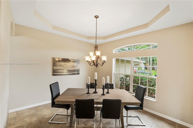 dining room with a tray ceiling, a wealth of natural light, and a notable chandelier