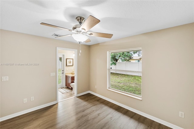 spare room with ceiling fan, wood-type flooring, and a textured ceiling