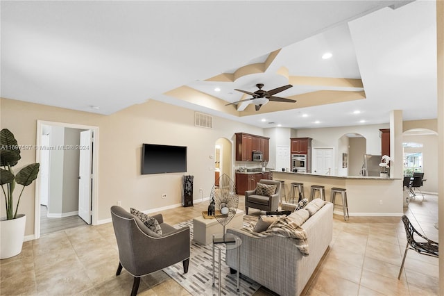 tiled living room featuring ceiling fan and vaulted ceiling