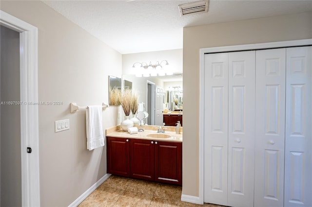 bathroom featuring vanity, a textured ceiling, and tile patterned floors