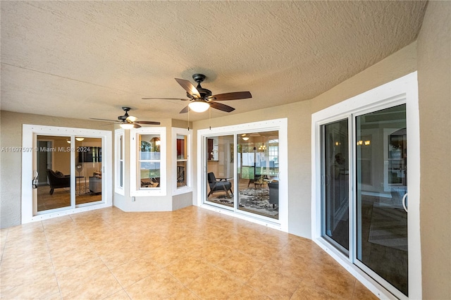 unfurnished sunroom featuring ceiling fan