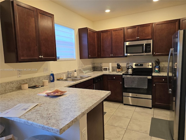 kitchen with sink, kitchen peninsula, a kitchen bar, light tile patterned floors, and appliances with stainless steel finishes