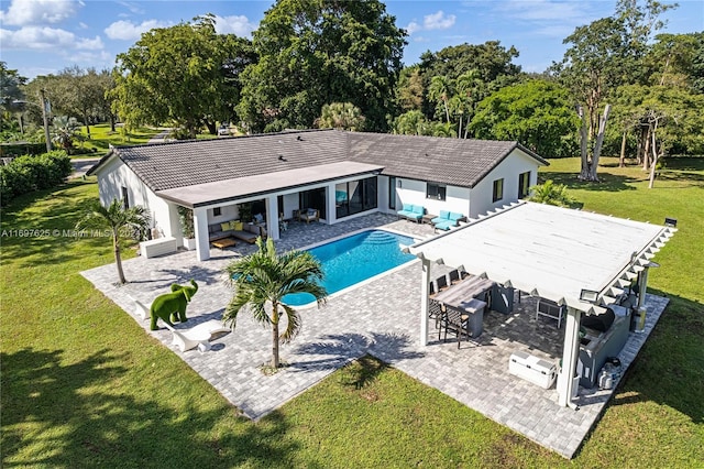 view of swimming pool with exterior bar, a yard, an outdoor living space, and a patio area