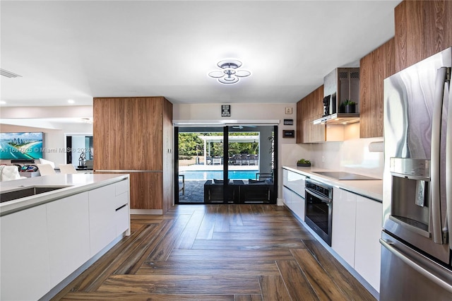 kitchen with white cabinets, appliances with stainless steel finishes, dark parquet floors, and sink