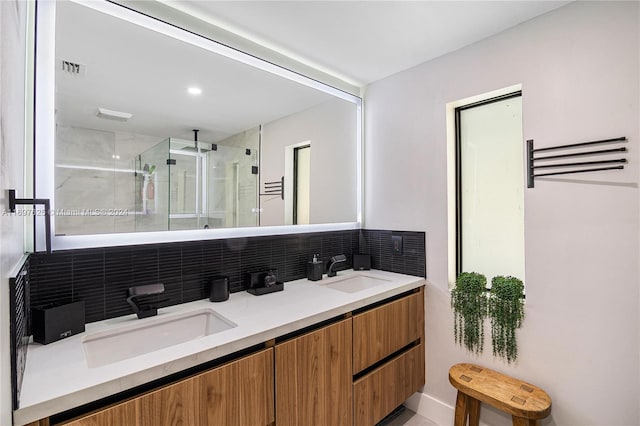 bathroom featuring vanity, tasteful backsplash, and an enclosed shower