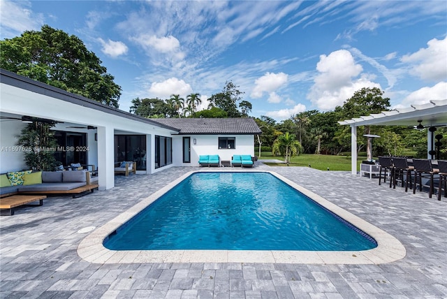 view of swimming pool featuring a patio area, an outdoor living space, and ceiling fan