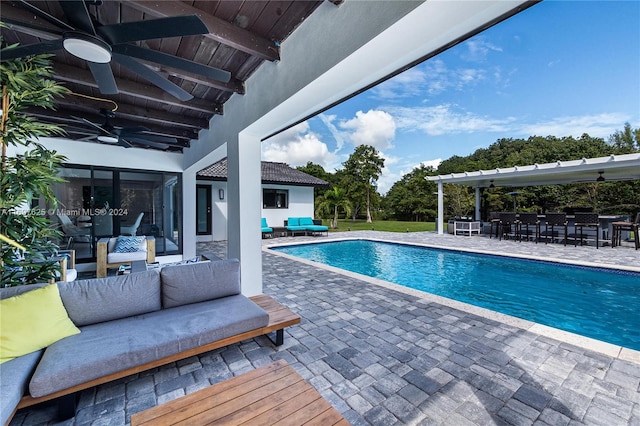 view of swimming pool with a patio area, ceiling fan, an outdoor bar, and an outdoor hangout area