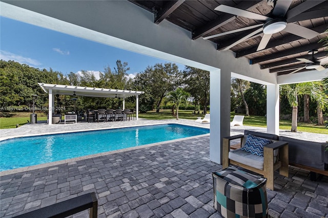 view of swimming pool with ceiling fan, a patio area, and an outdoor bar