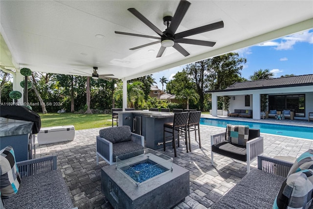 view of patio / terrace with a bar and an outdoor living space with a fire pit