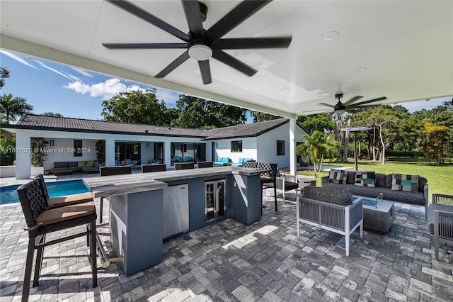 view of patio / terrace featuring an outdoor living space, a bar, and ceiling fan