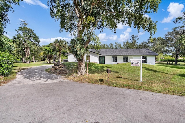 single story home featuring a front lawn