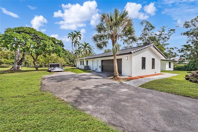 view of home's exterior featuring a lawn, central AC unit, and a garage