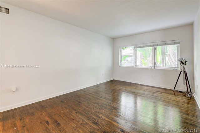 empty room with dark wood-type flooring