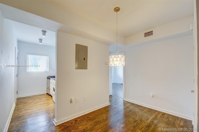 empty room featuring electric panel and hardwood / wood-style flooring