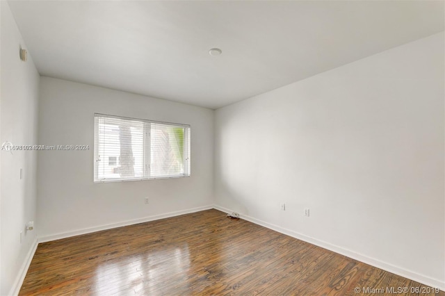 empty room with dark hardwood / wood-style flooring