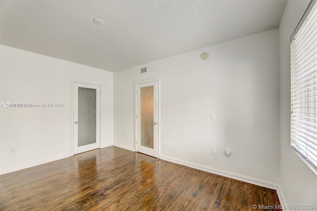 unfurnished room featuring dark hardwood / wood-style floors and french doors