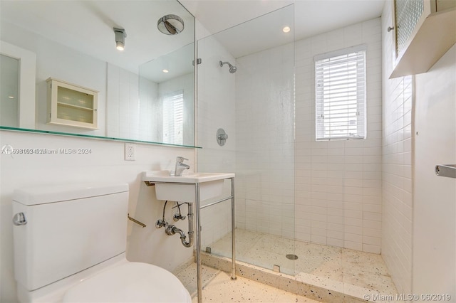 bathroom featuring toilet and a tile shower