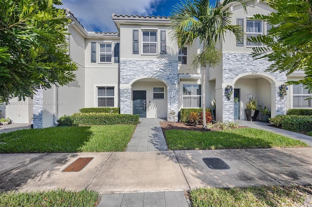 mediterranean / spanish home with a front yard