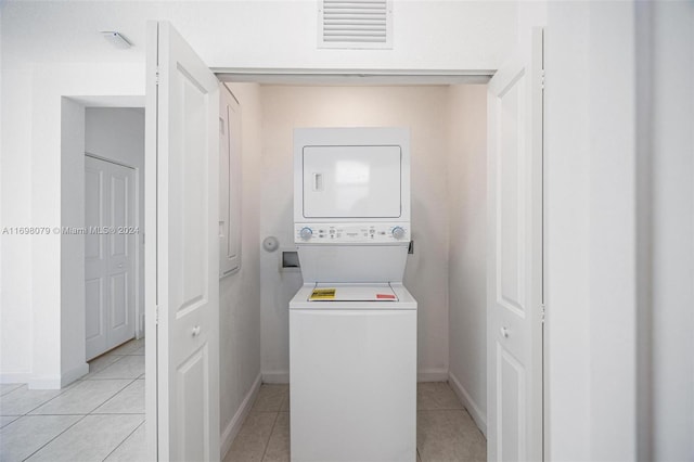 washroom with light tile patterned floors and stacked washer and dryer