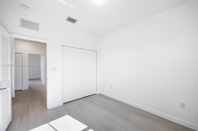 unfurnished bedroom with a closet and light hardwood / wood-style flooring