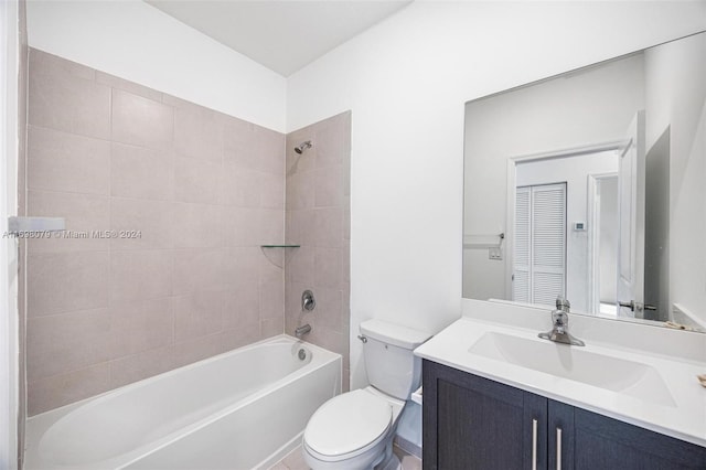 full bathroom featuring vanity, tiled shower / bath combo, and toilet