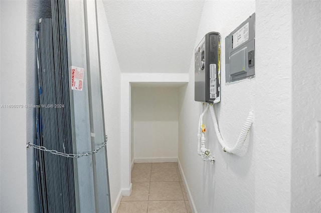 hall with light tile patterned floors and a textured ceiling