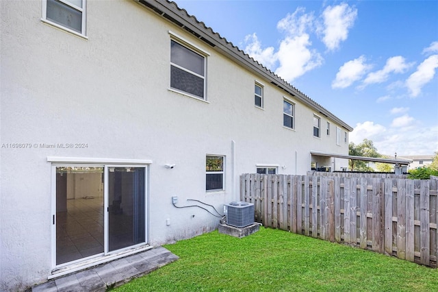 back of house with a lawn and central air condition unit