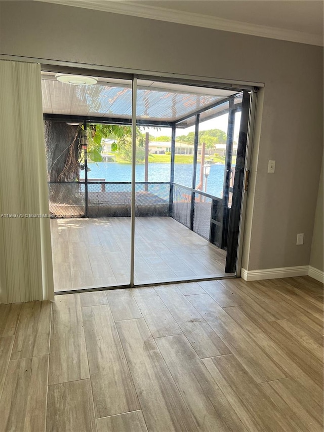 empty room featuring hardwood / wood-style floors, a water view, and ornamental molding