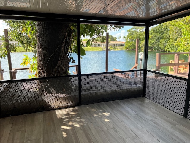 unfurnished sunroom with plenty of natural light, a water view, and wooden ceiling