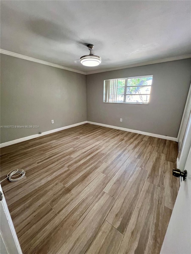 unfurnished room featuring light wood-type flooring and ornamental molding