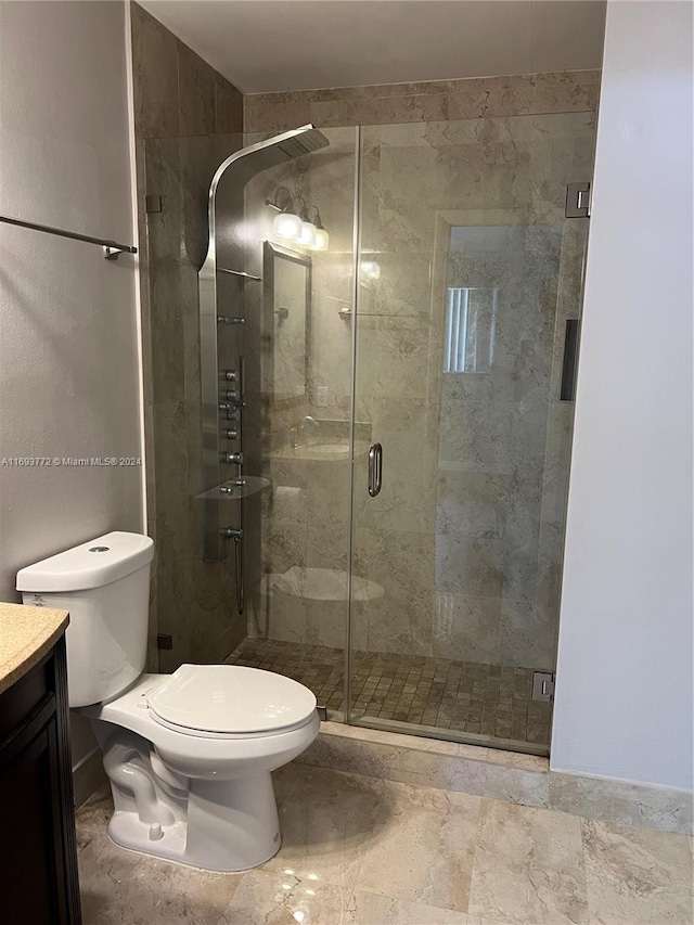 bathroom featuring vanity, toilet, and an enclosed shower