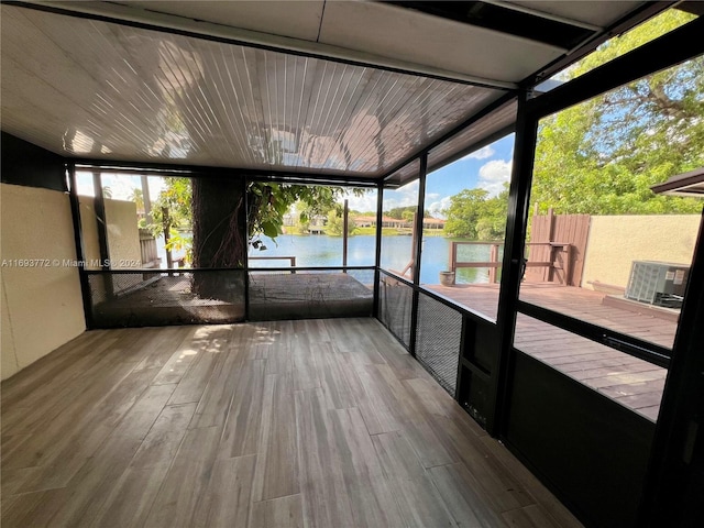 unfurnished sunroom featuring a water view