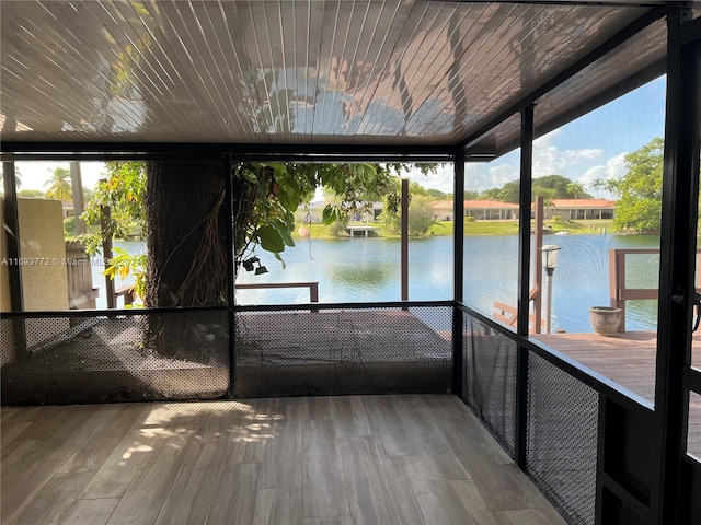 unfurnished sunroom featuring a water view and wood ceiling