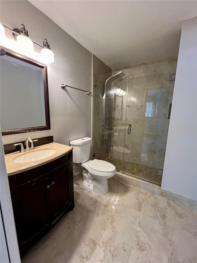 bathroom featuring vanity, an enclosed shower, and toilet