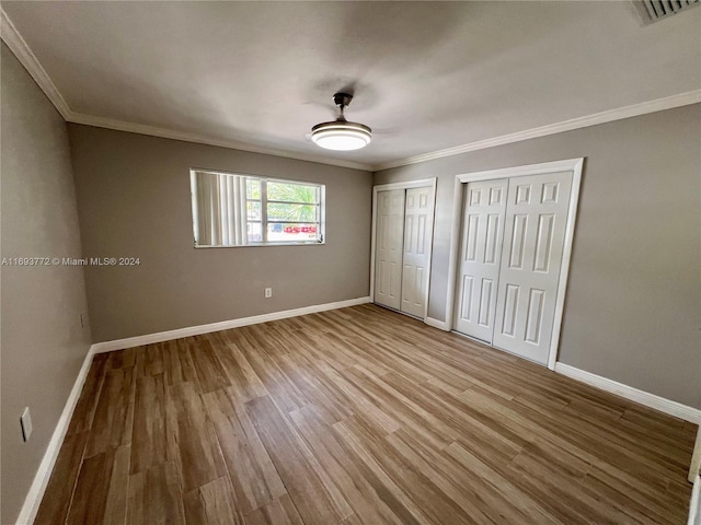 unfurnished bedroom with ceiling fan, light hardwood / wood-style floors, and ornamental molding