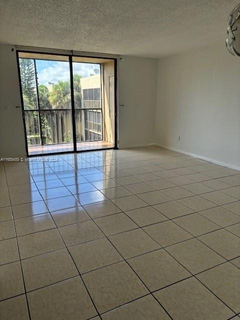 spare room with light tile patterned floors and a textured ceiling