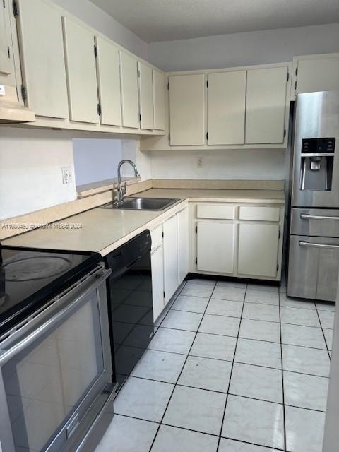 kitchen with light tile patterned flooring, exhaust hood, stainless steel appliances, and sink